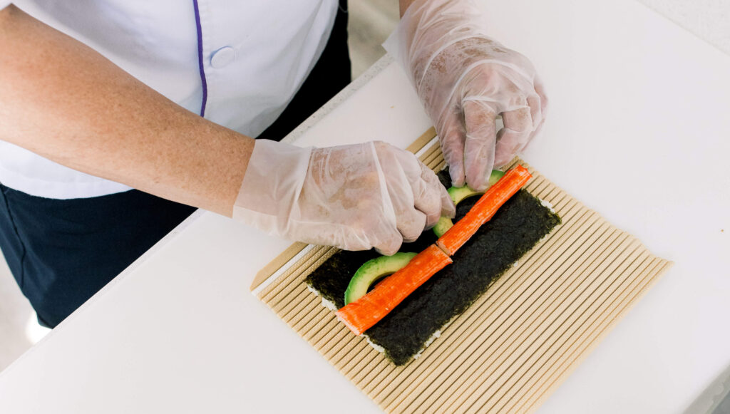 A person hand rolling sushi